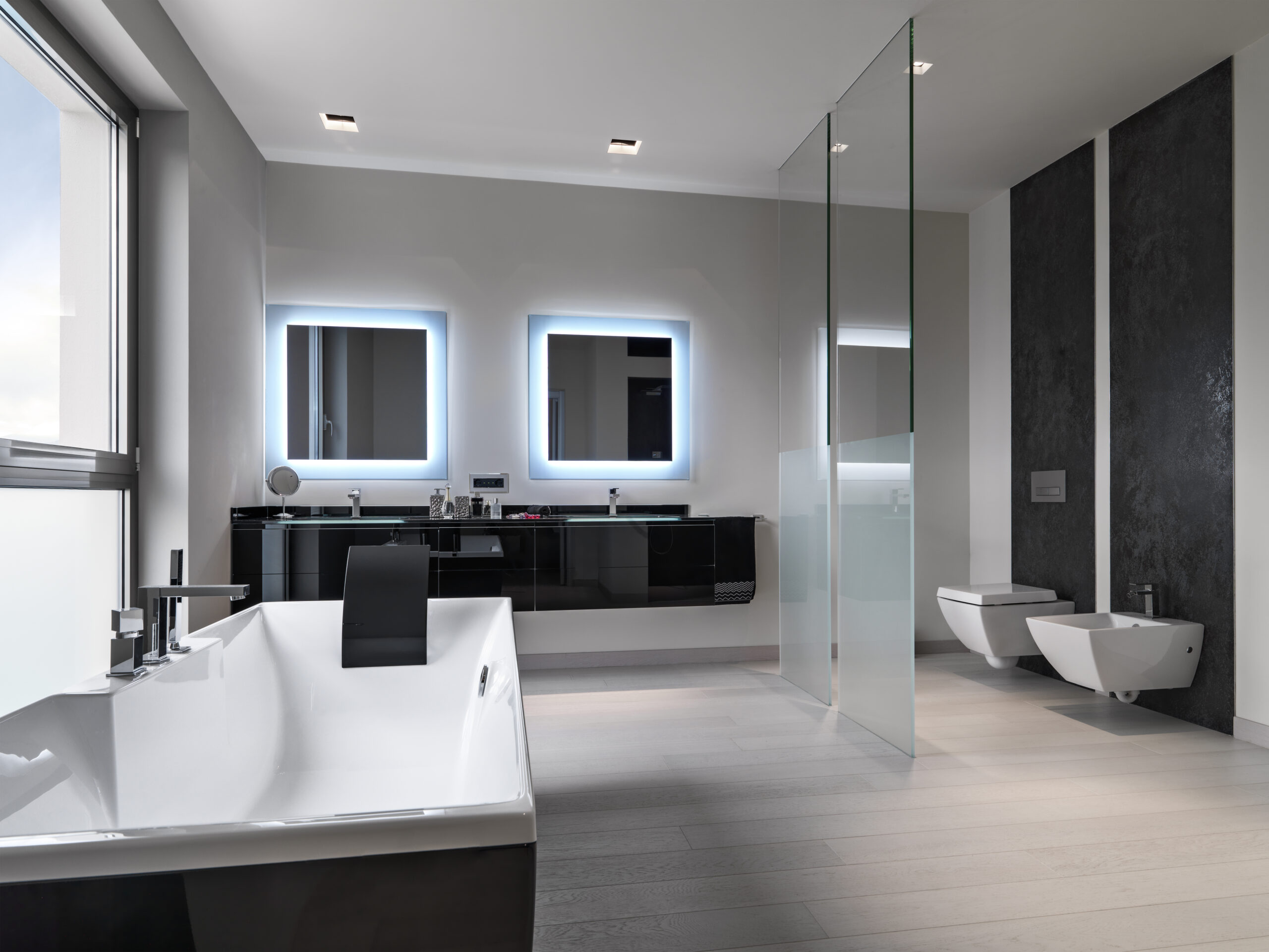 interiors shots of a modern bathroom in the foreground the bathtub in the background the washbasin furniture and the toilet bowl and bidetand